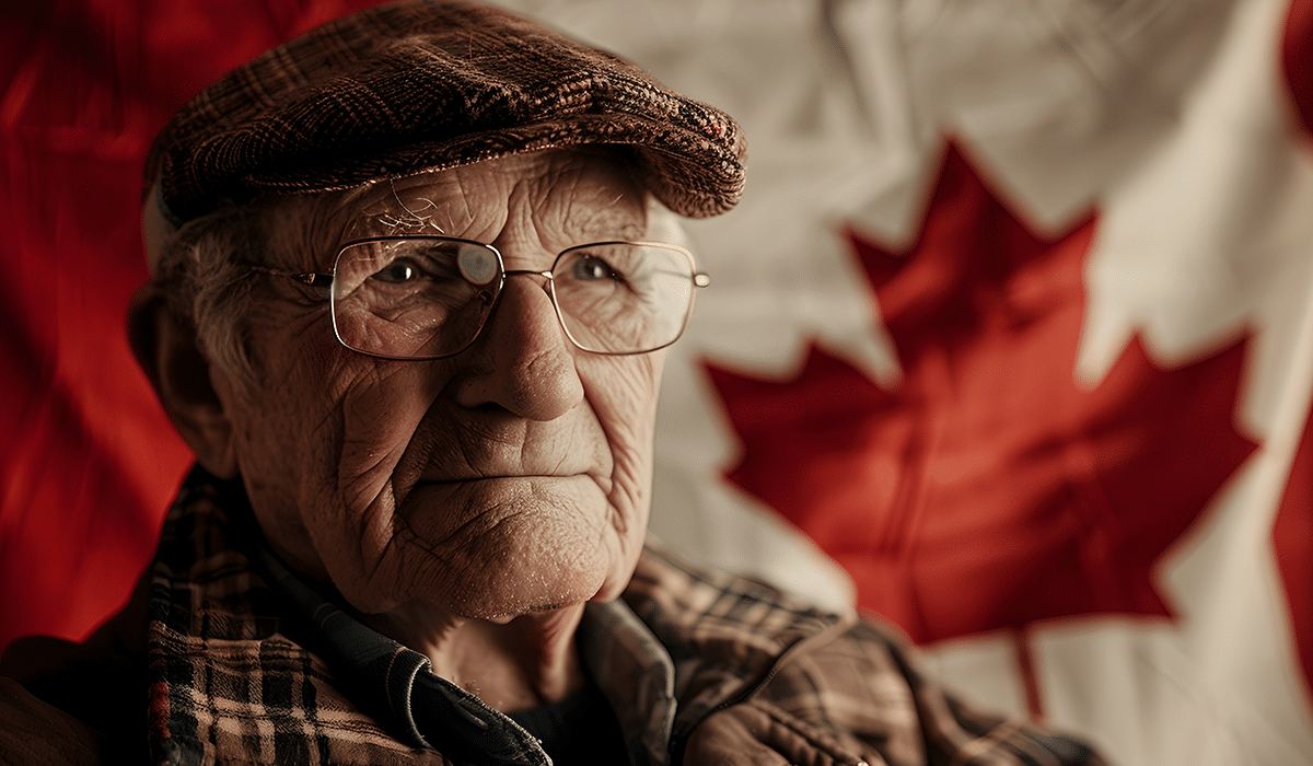 canadian senior Senior man in a hat sitting in front of a Canadian flag