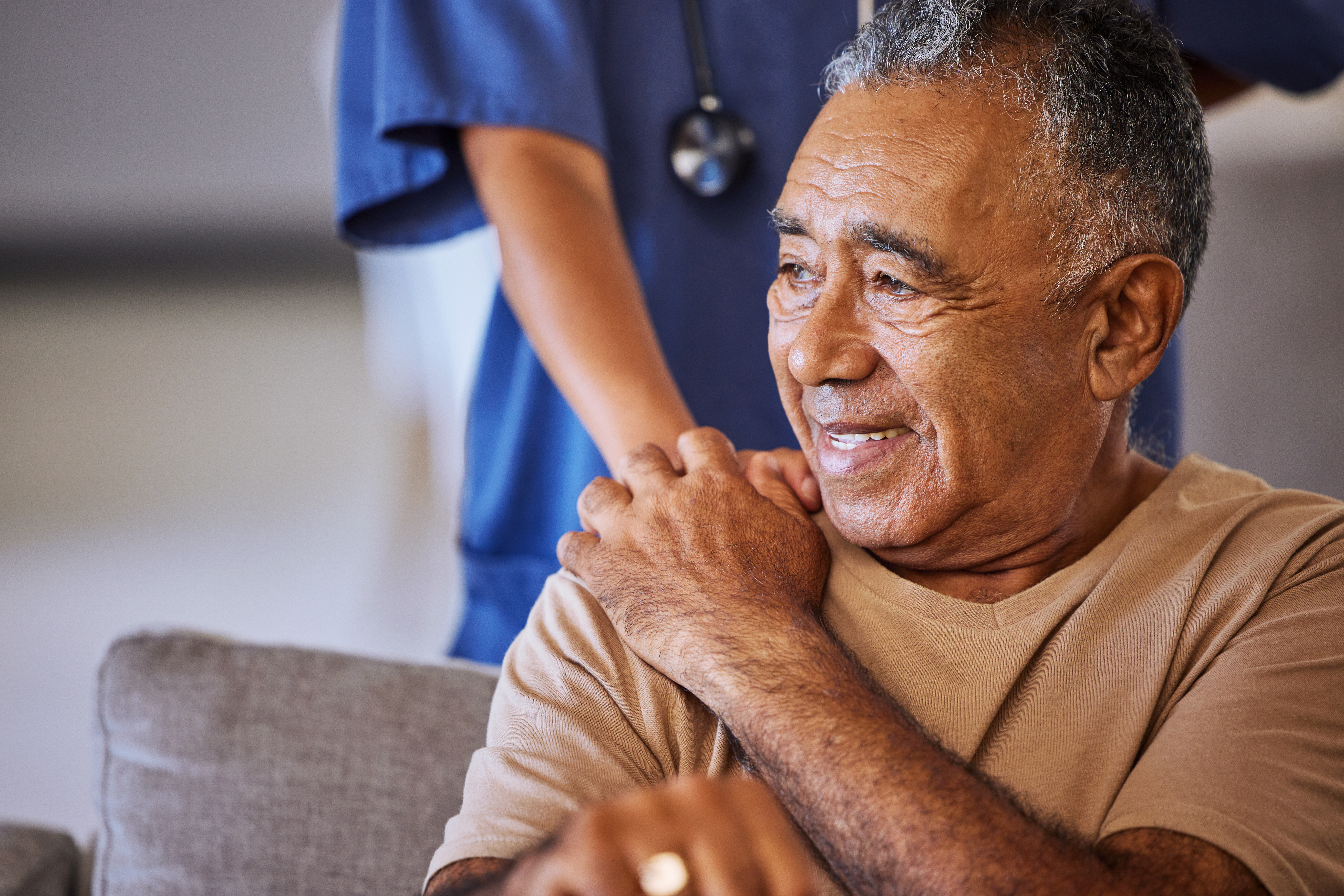 nurse holding hands with senior man
